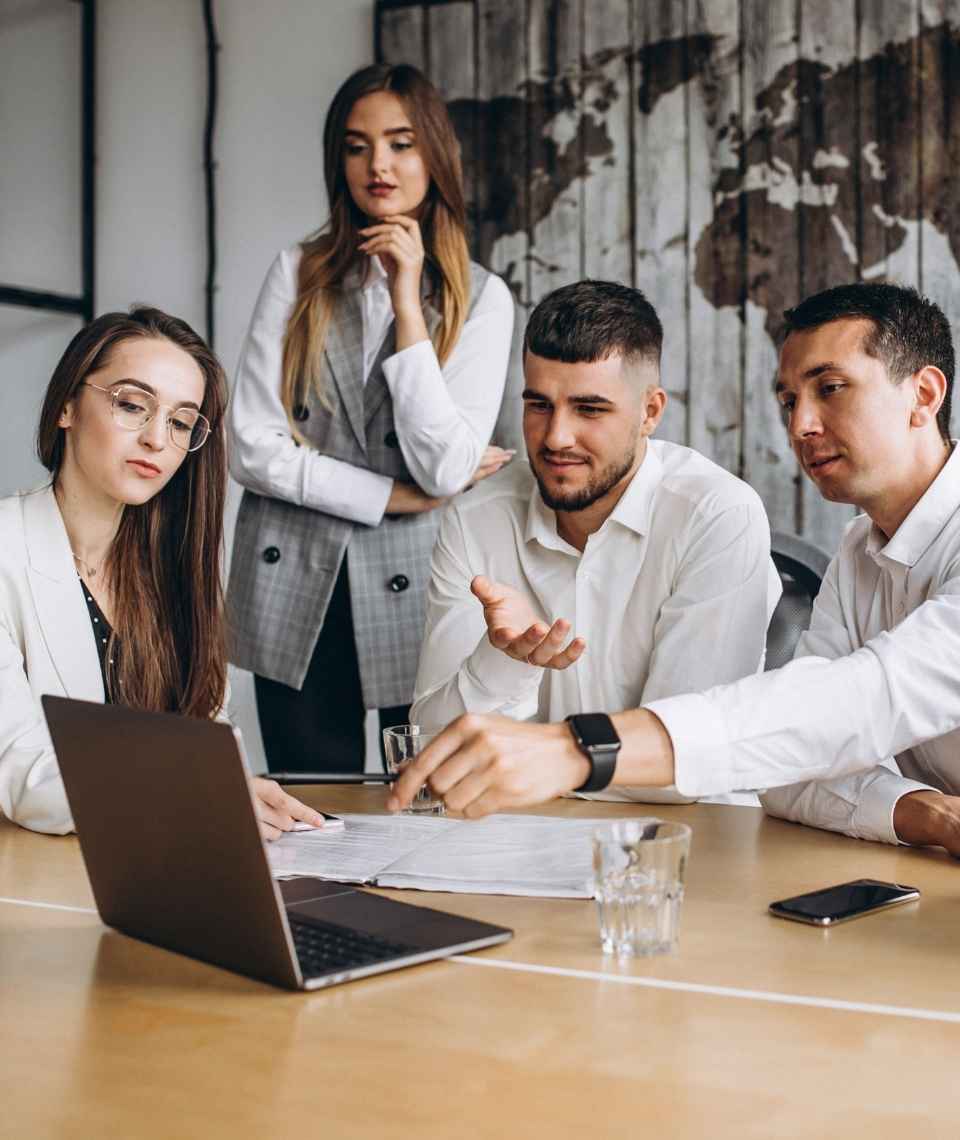 Team discussing project around laptop